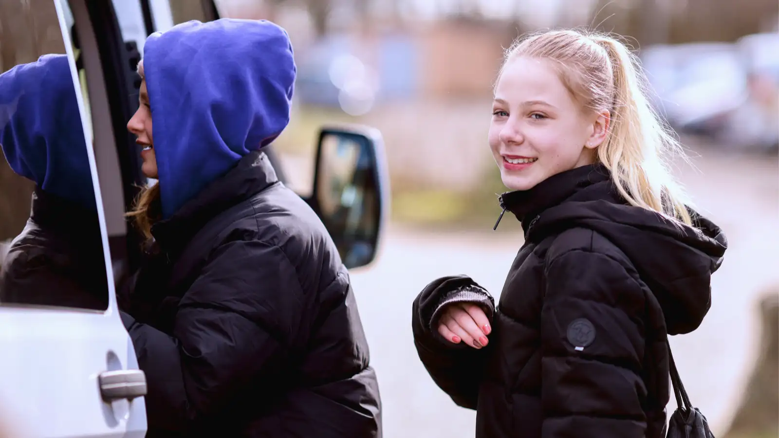 Ein Mädchen und ein Junge steigen in einen Transporter