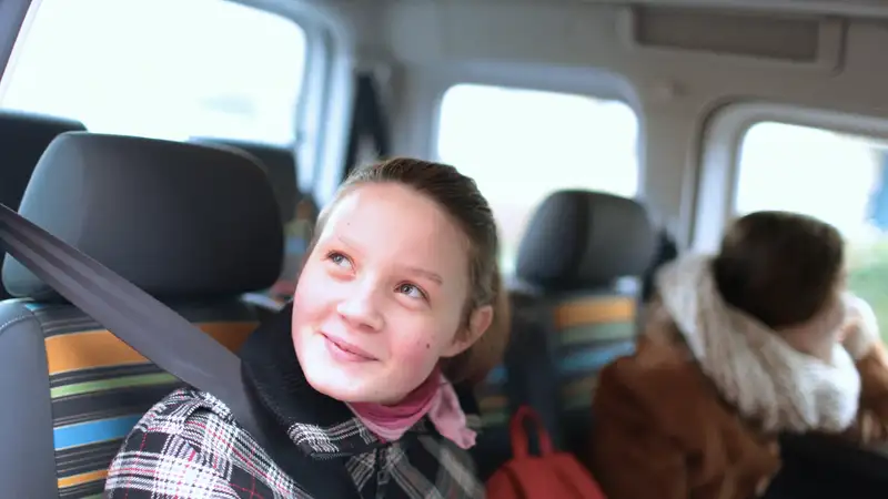 Ein Mädchen in einem Transporter schaut durch die geöffnete Tür nach draußen
