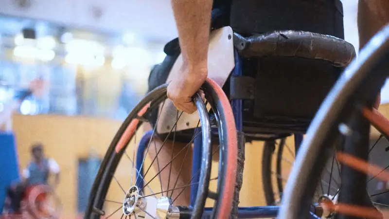 Eine Person im Rollstuhl in einer Sporthalle