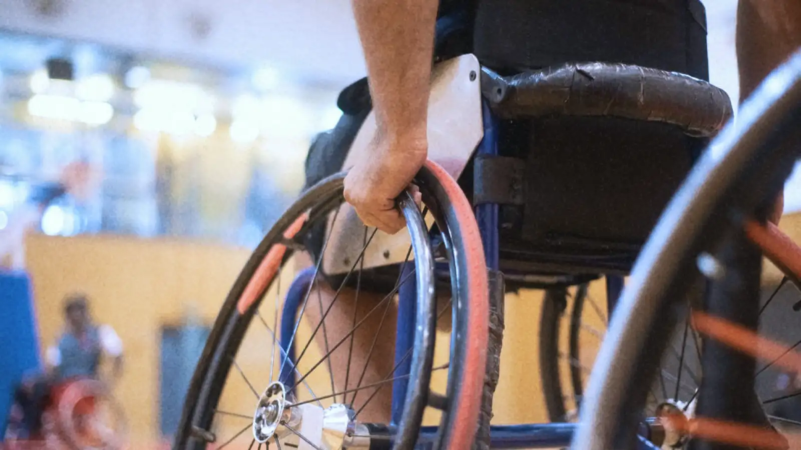 Eine Person im Rollstuhl in einer Sporthalle