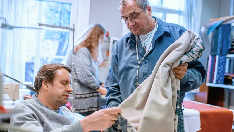Zwei Männer betrachten ein genähtes Kleidungsstück