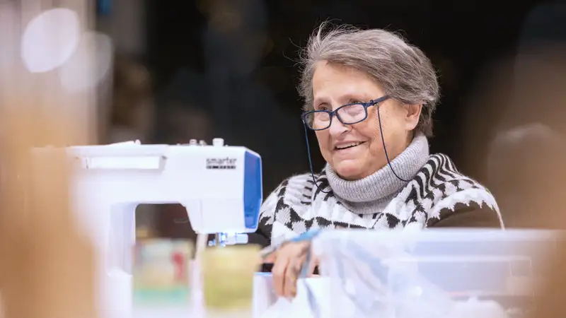 Eine Frau sitzt vor einer Nähmaschine