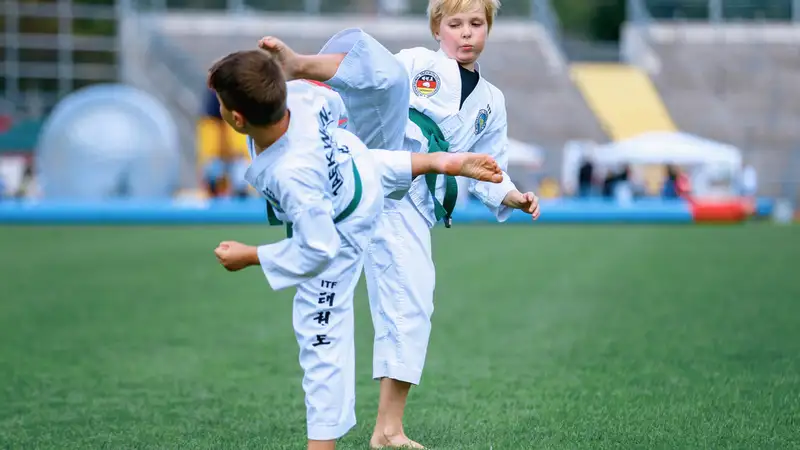 Zwei Jungen machen Judo auf einem Fußballfeld