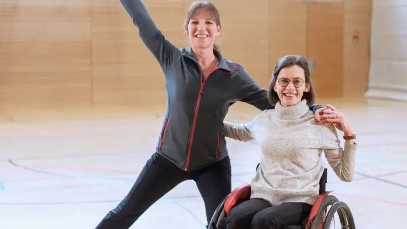Zwei Frauen bei einer Tanzpose in einer Sporthalle