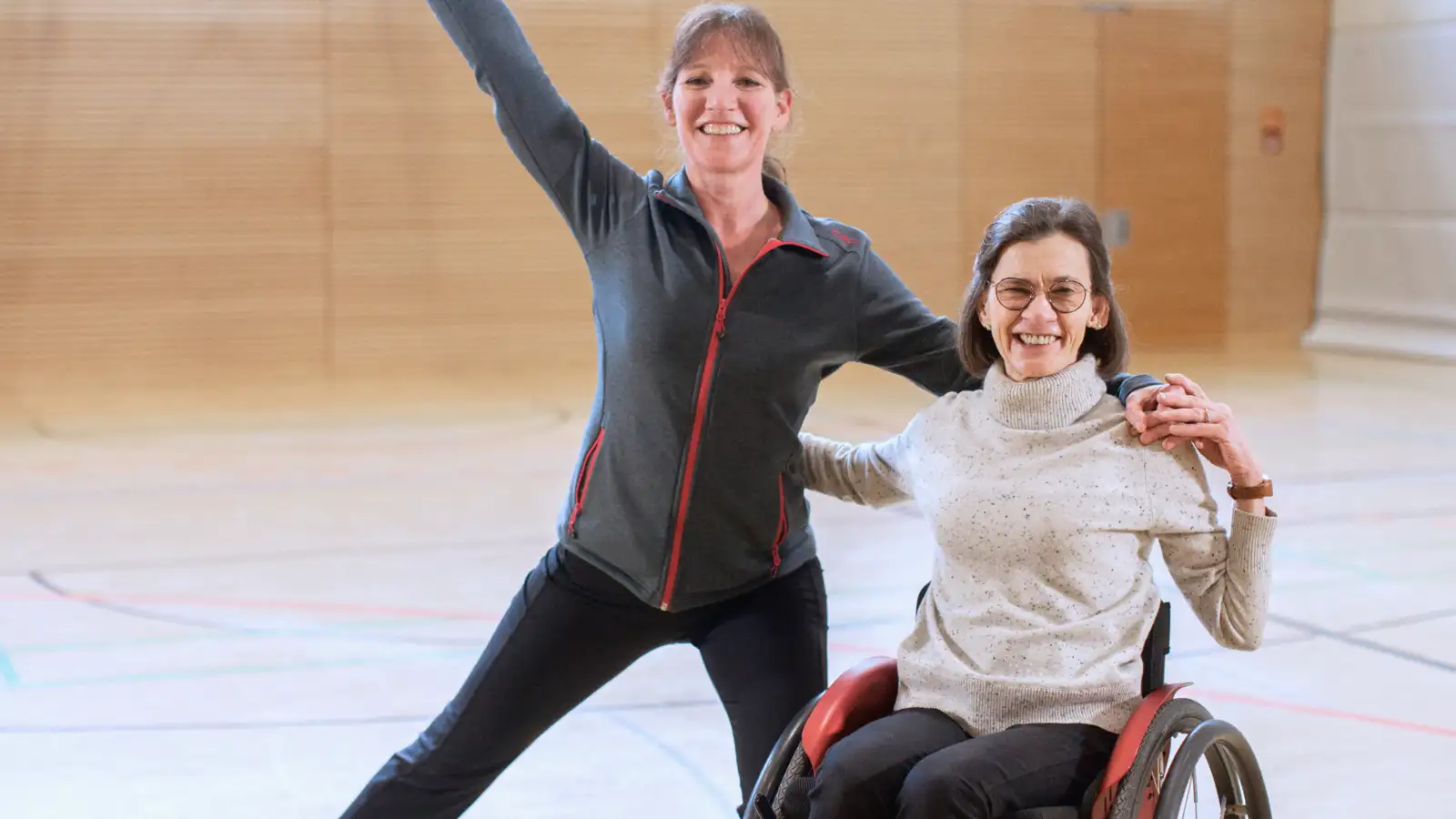 Zwei Frauen bei einer Tanzpose in einer Sporthalle