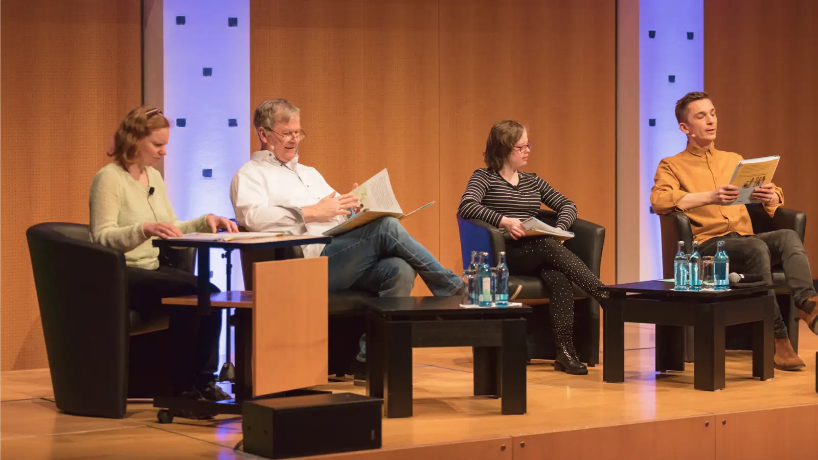 Vier Personen auf einer Bühne bei einer Podiumsdiskussion