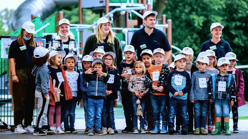 Eine Gruppe von Kindergartenkindern ihren Erzieher*innen im Freien.