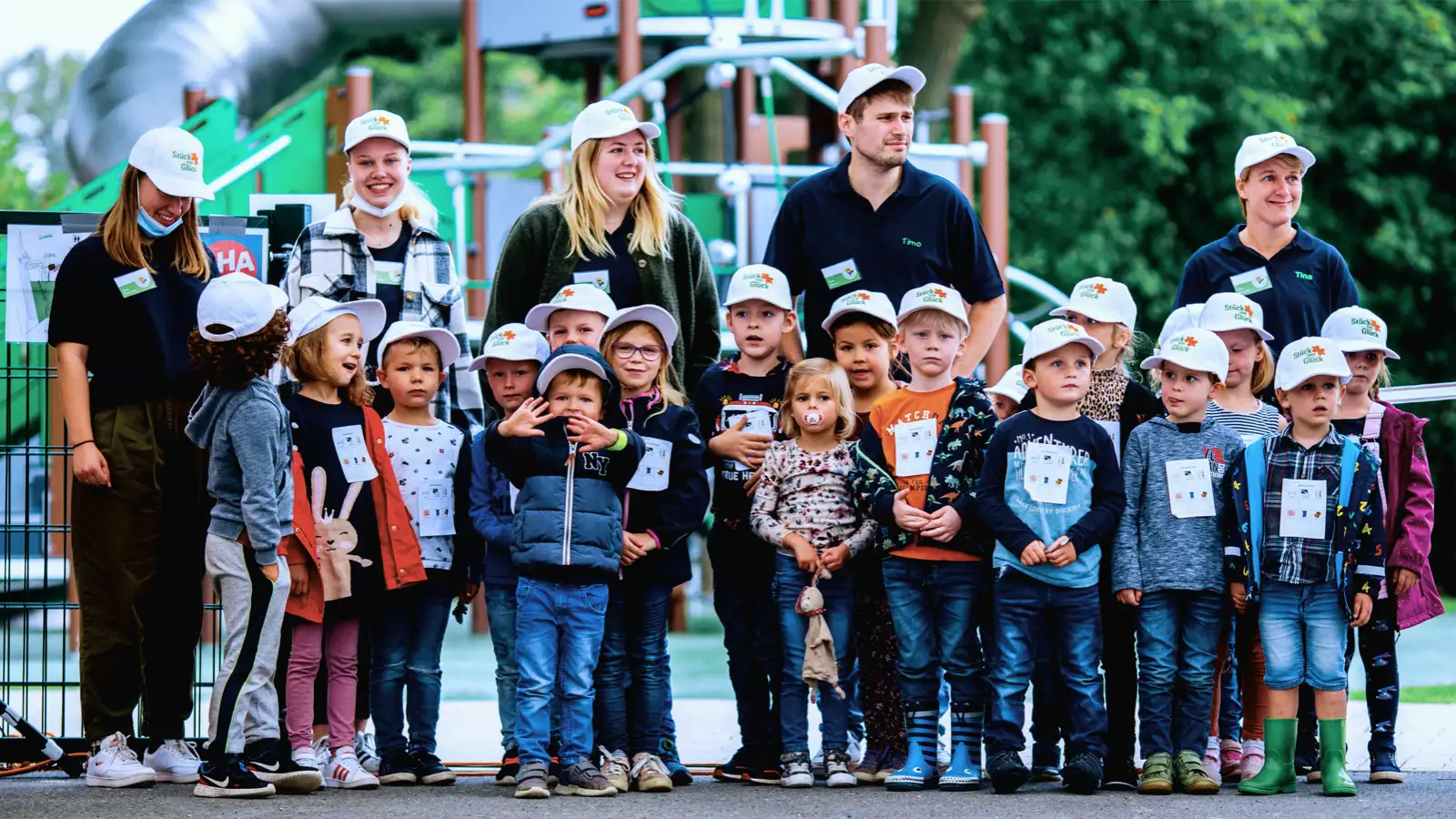 Eine Gruppe von Kindergartenkindern ihren Erzieher*innen im Freien.