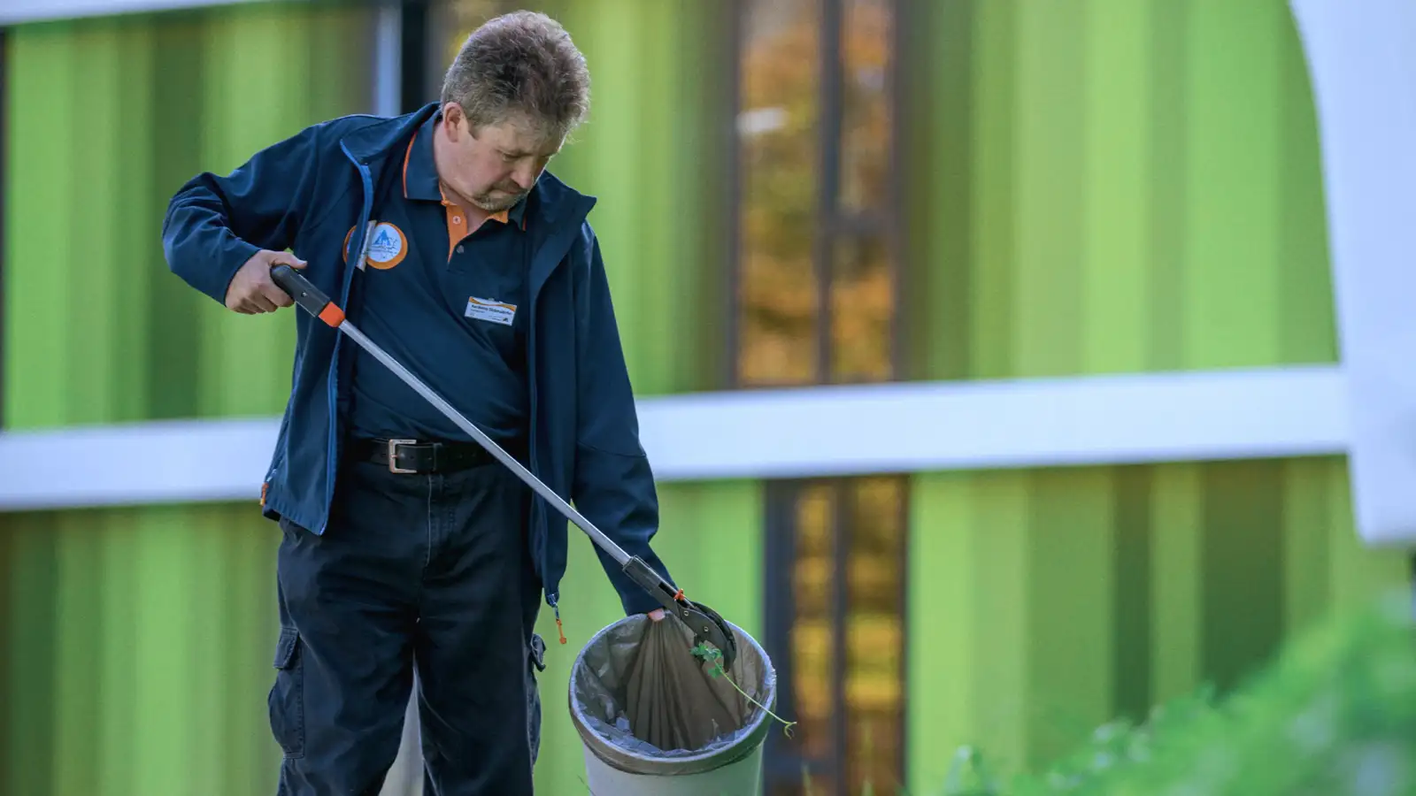 Ein Mann beim Aufsammeln von Müll im Freien