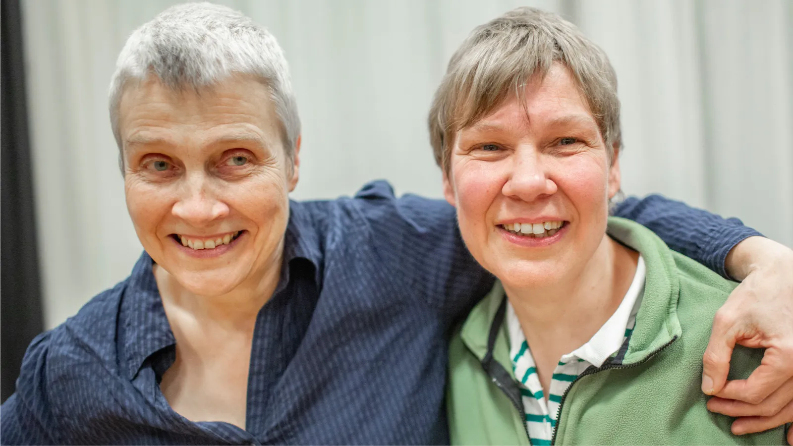 Zwei lachende Seniorinnen, die sich umarmen