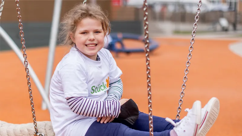 Ein Mädchen im Kindergartenalter auf einer Schaukel