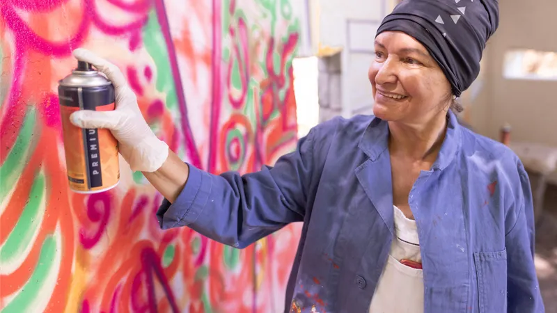 Eine Frau sprüht Graffiti in einem Atelier.