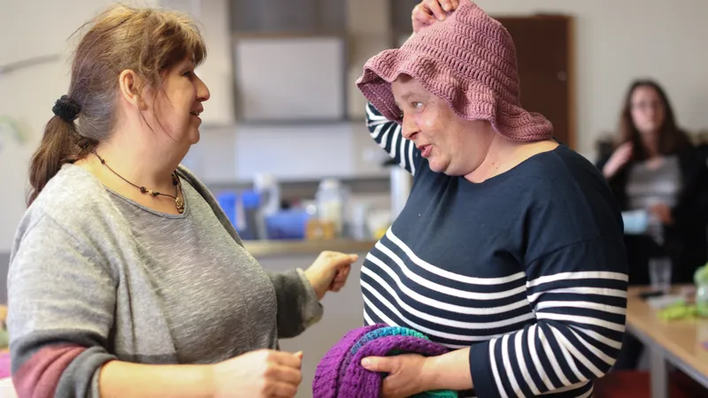Zwei Frauen, eine trägt eine gehäkelte rosafarbene Mütze