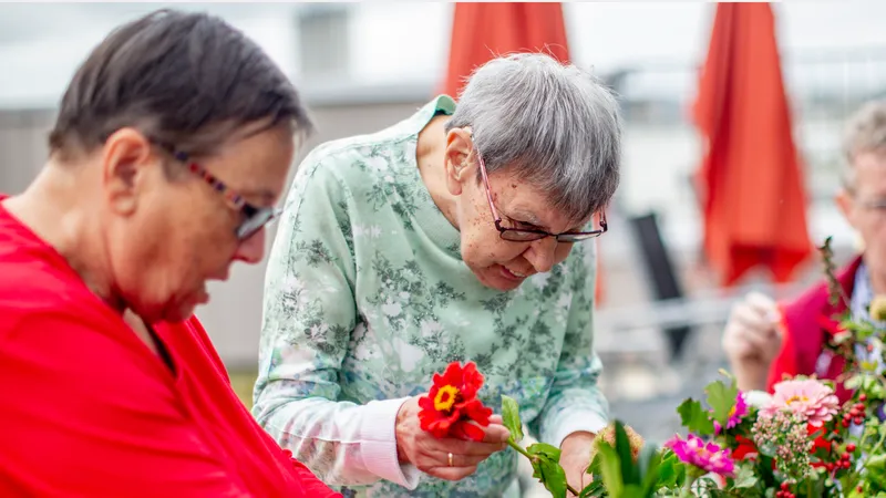 Drei ältere Menschen bei der Pflege von Blumen
