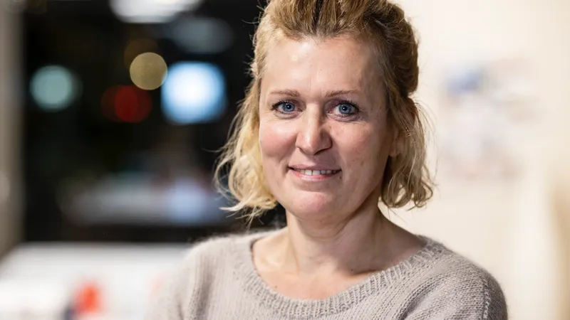 Eine Frau in einem Besprechungsraum schaut in die Kamera