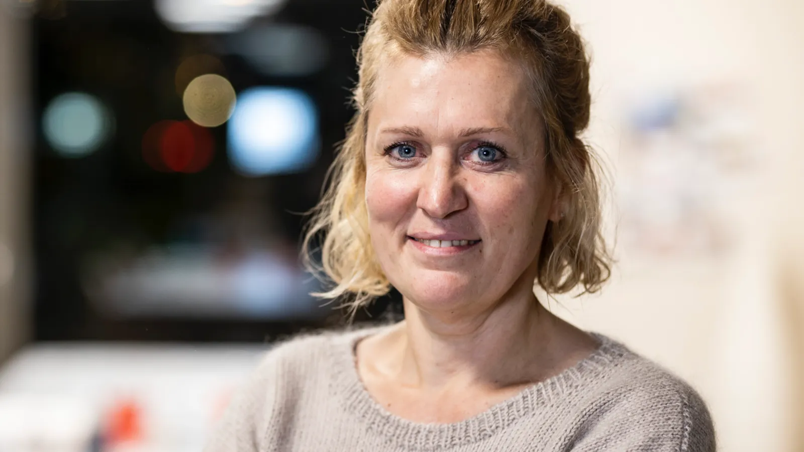 Eine Frau in einem Besprechungsraum schaut in die Kamera