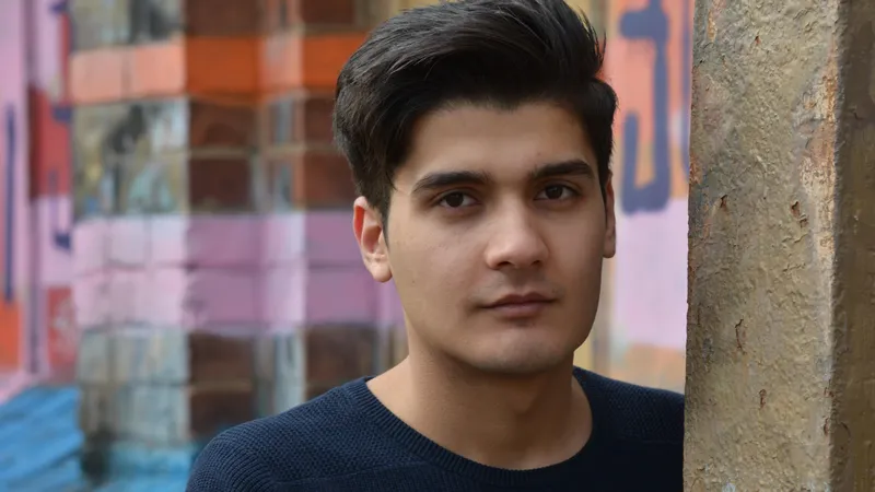 Ein junger Mann blickt ernst in die Kamera