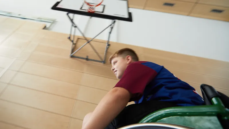 Ein Jungen im Rollstuhl vor einem Basketball-Korb
