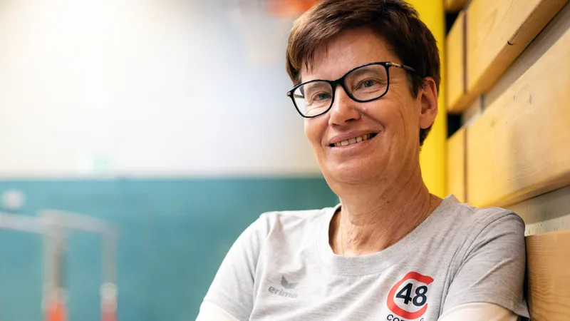 Eine Frau vor Hintergrund einer Turnhalle
