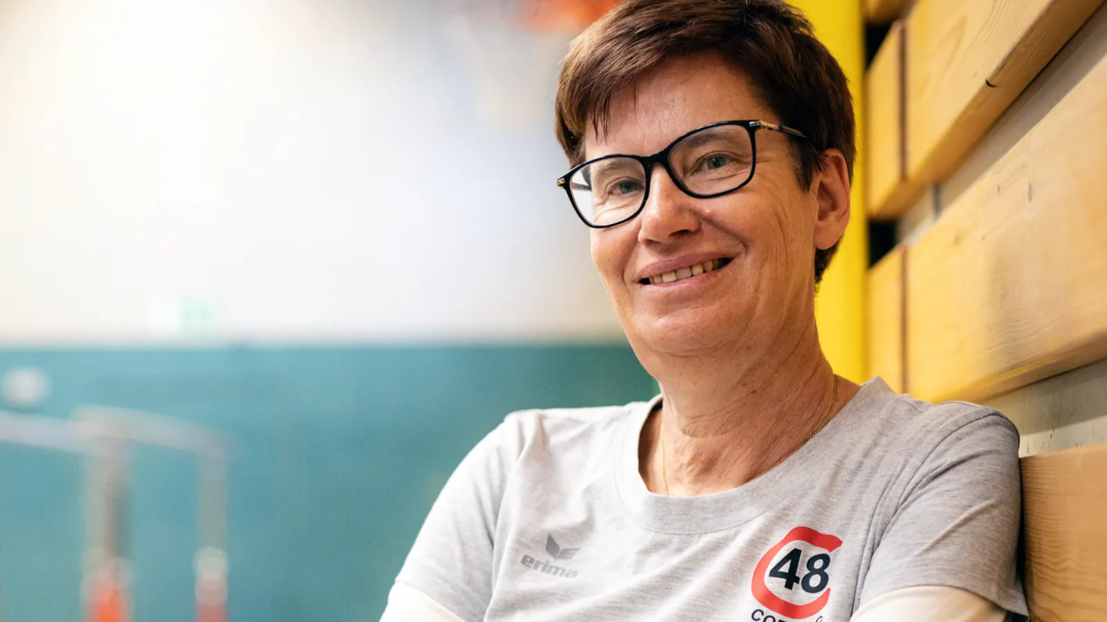 Eine Frau vor Hintergrund einer Turnhalle