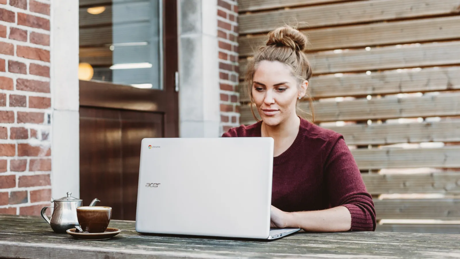 Eine junge Frau auf einem Balkon mit einem Laptop