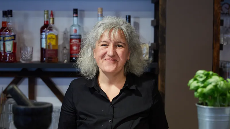 Eine Frau hinter einem Tresen lächelt in die Kamera