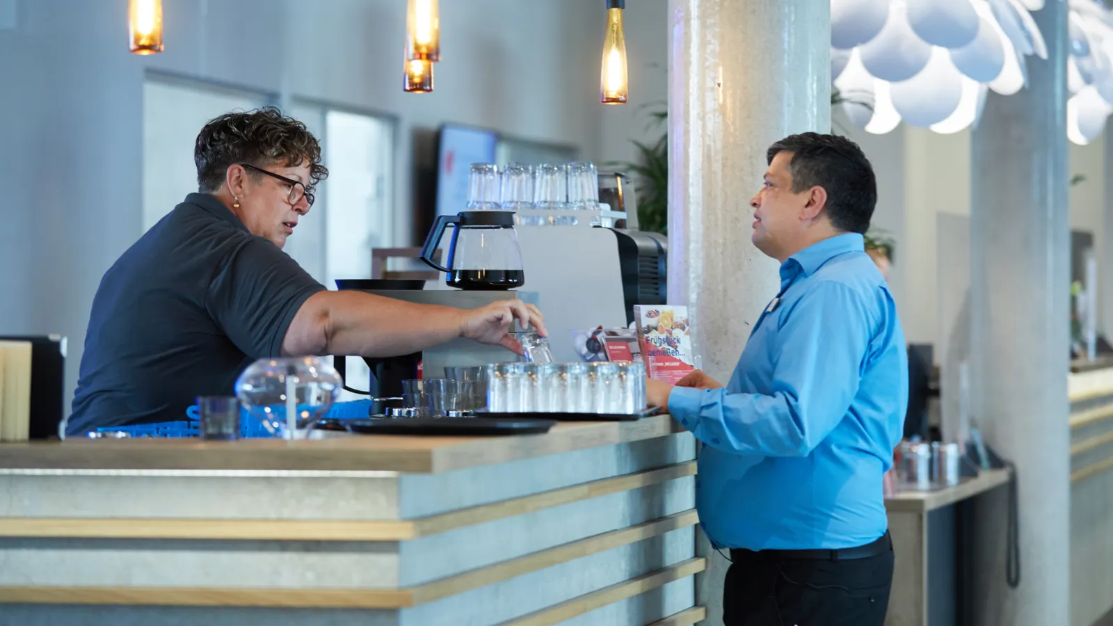 Eine Frau und ein Mann an einem Tresen in einem Café