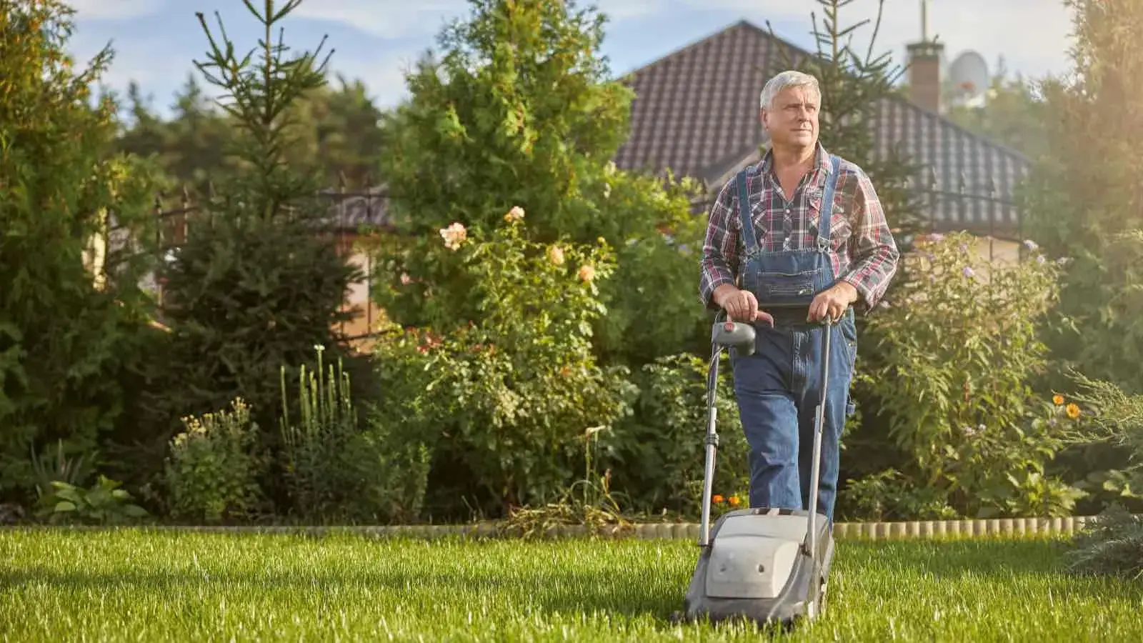 Ein Mann mit Rasenmäher im Garten