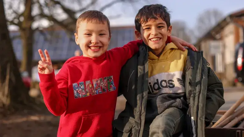 Zwei Jungen im Freien lächeln in die Kamera