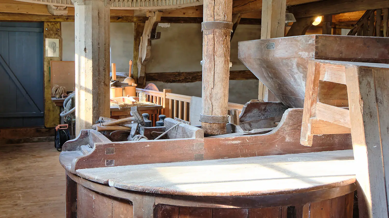 Holzkonstruktion eines alten Mahlgewölbes mit Mahlsteinen und Mahlwerk in einer historischen Mühle.